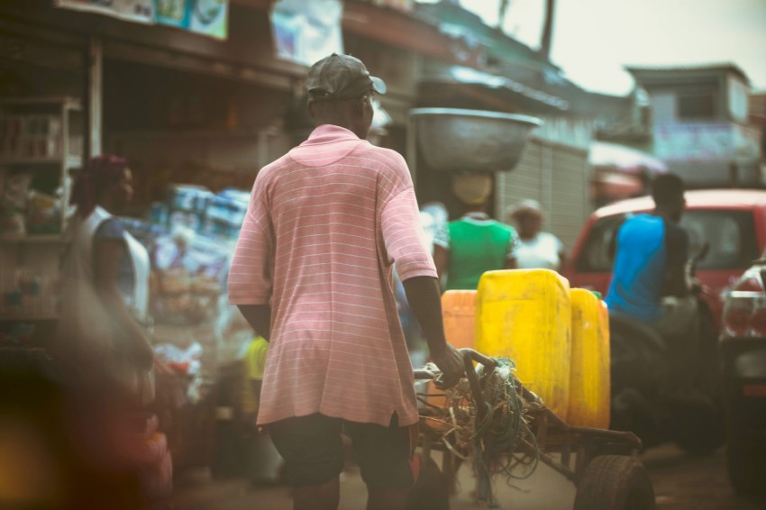 a woman walking down a street with a cart