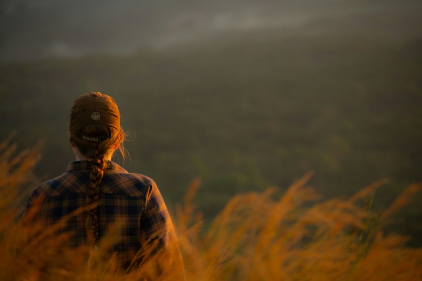 a person standing in a field of tall grass