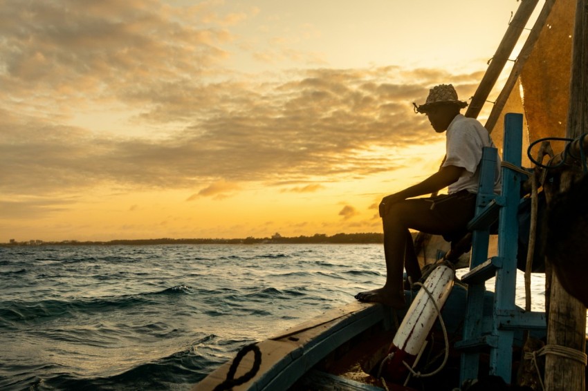 a man sitting on a boat in the ocean