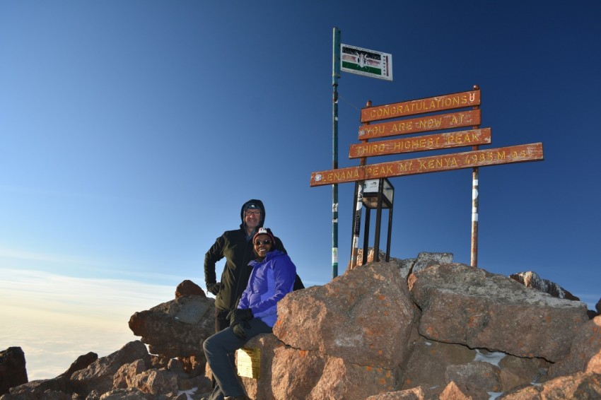 man and woman standing on mountains peak iki5