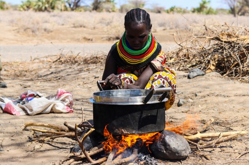 a woman cooking food over an open fire