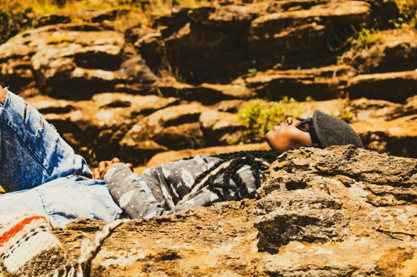 a man laying on top of a rocky hillside