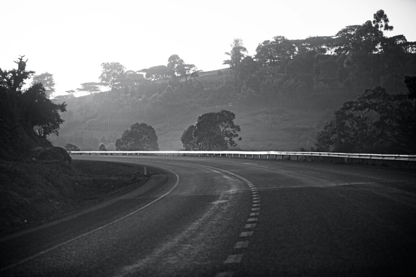 a black and white photo of a winding road