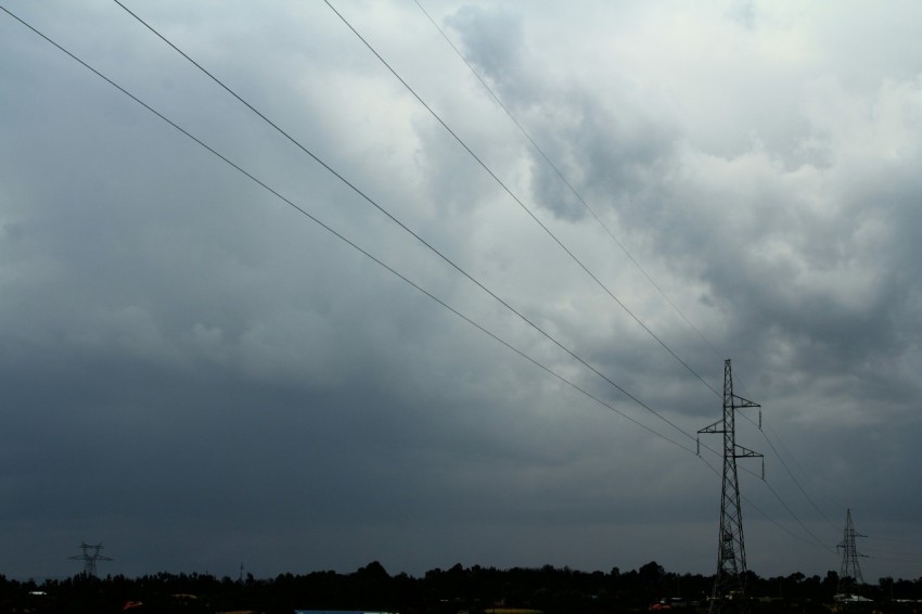 a cloudy sky with power lines in the foreground