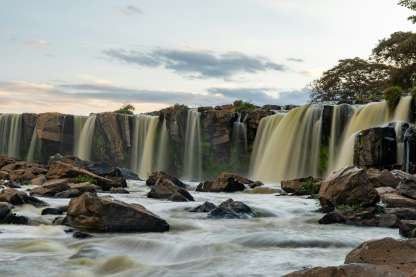 a waterfall with rocks and trees