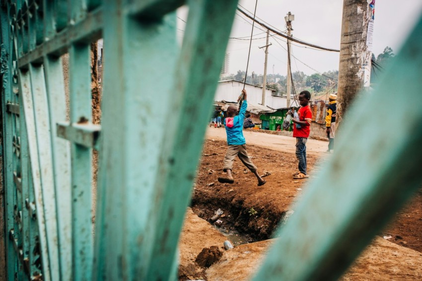 kids playing on cable by gate during daytime