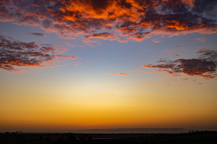 the sun is setting in the sky over a field