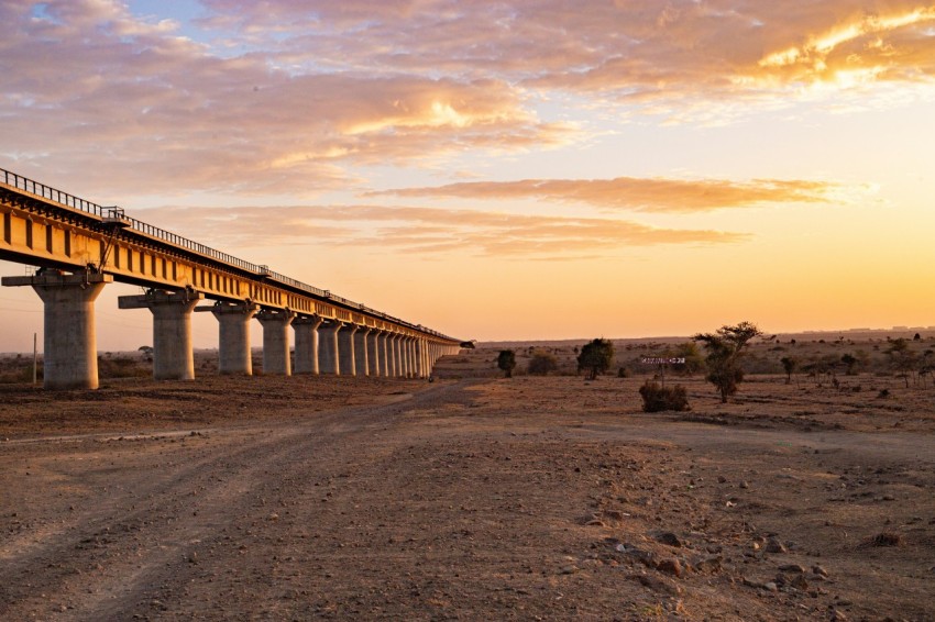 a bridge over a dirt road in the desert