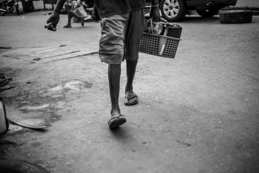 a man walking down a street carrying a basket