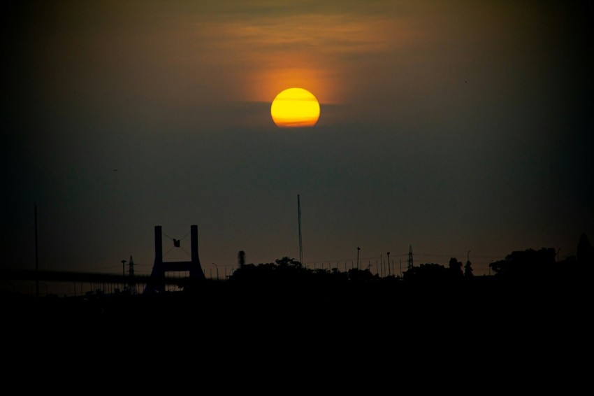 the sun is setting over the horizon of a city