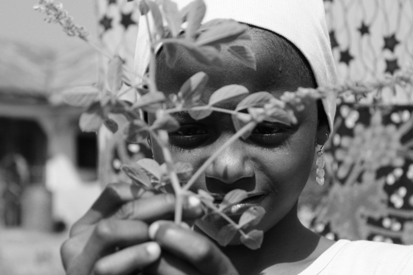 grayscale photography of girl holding plant