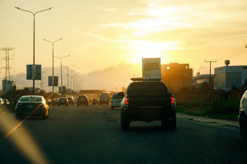 the sun is setting on a busy highway