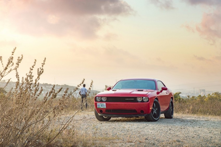 a red sports car parked on a gravel road