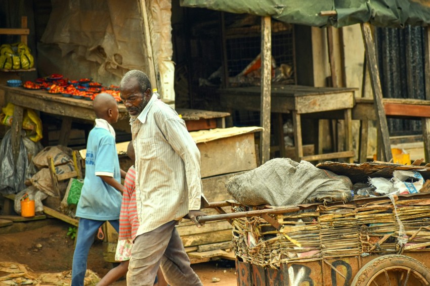 a man pushing a cart with a dead animal on it In