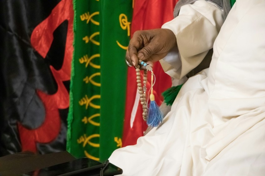 a man in a white robe holding a rosary