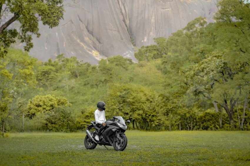 a person riding a motorcycle on a lush green field