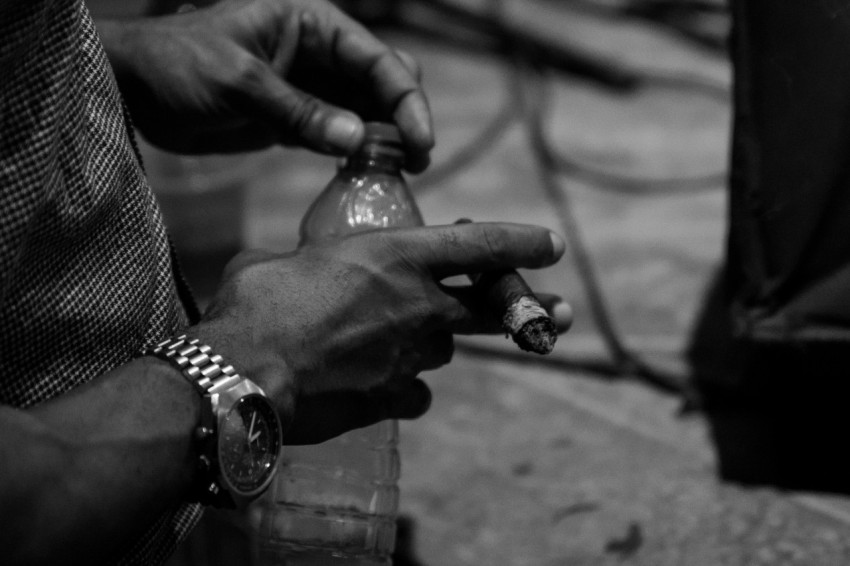 grayscale photo of person holding plastic bottle