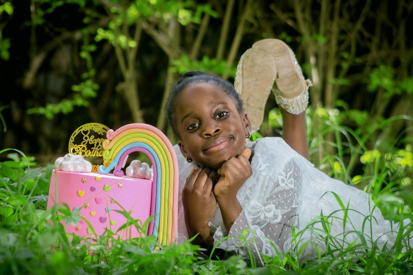 a little girl laying in the grass with her toys 2