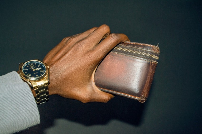 a person holding a wallet and a watch