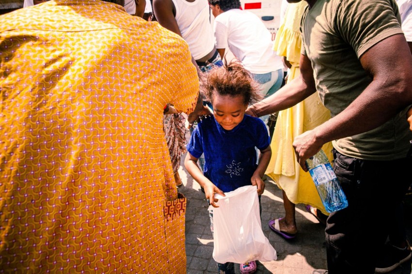 a little girl holding a white bag in her hands