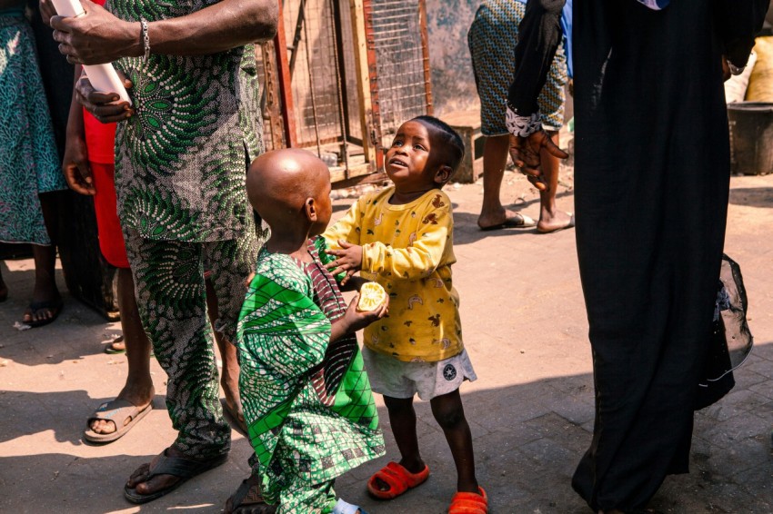 a little girl standing next to a little boy