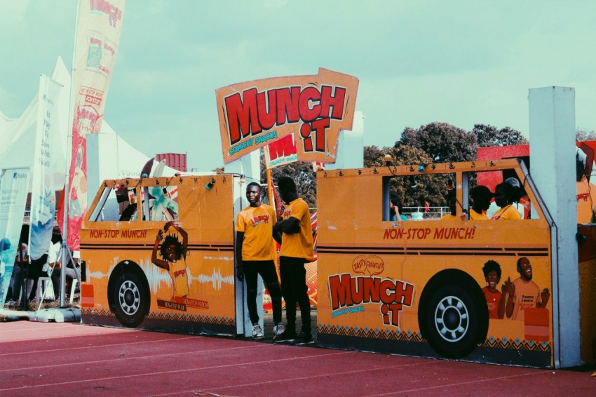 man in yellow shirt standing beside yellow bus