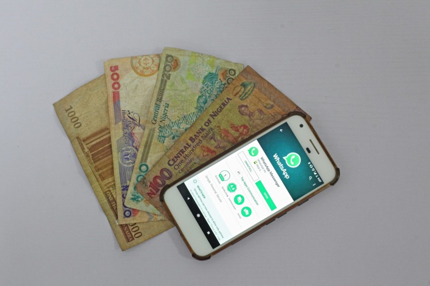 white android smartphone beside banknotes