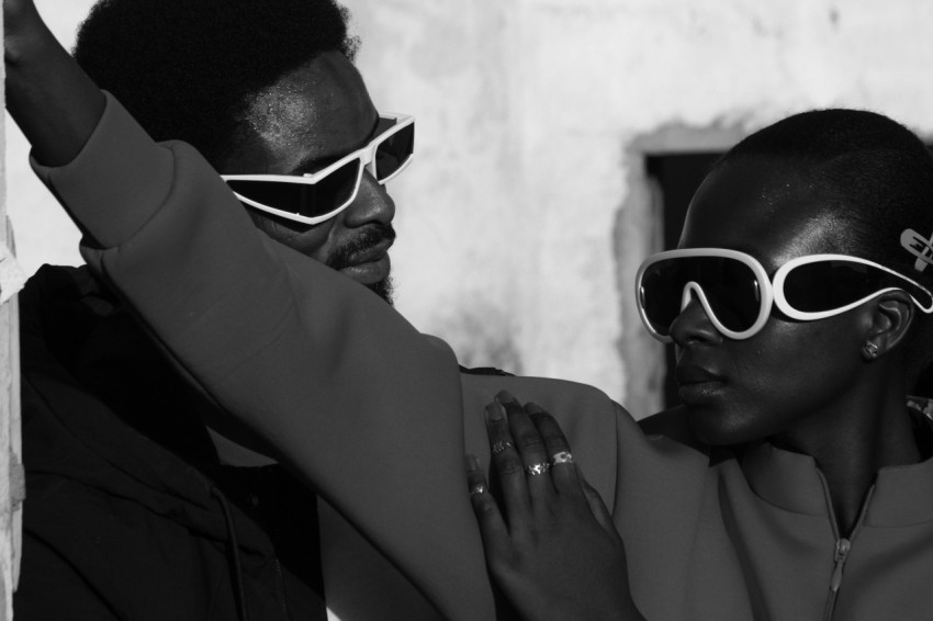 a man and a woman wearing white sunglasses NzL