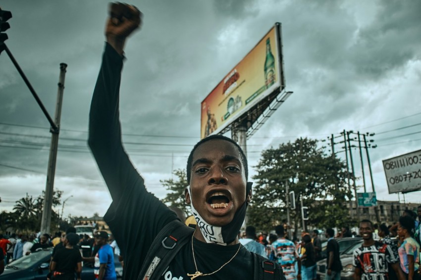 a man holding up a sign in front of a crowd ceawFbpA