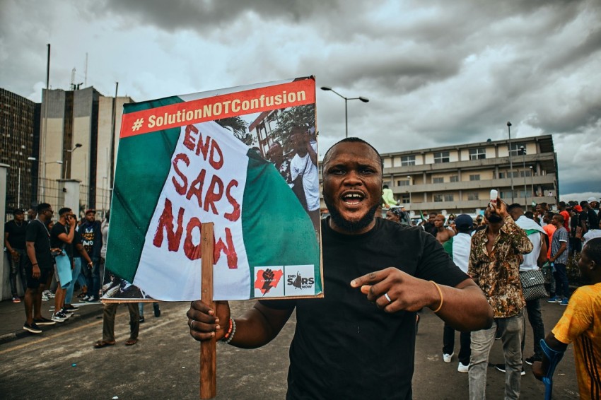 a man holding a sign that says end sars now 6B9c5cR