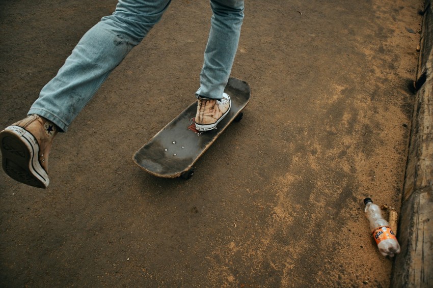 person in blue denim jeans standing on black and red skateboard during daytime 7i2QNG1w