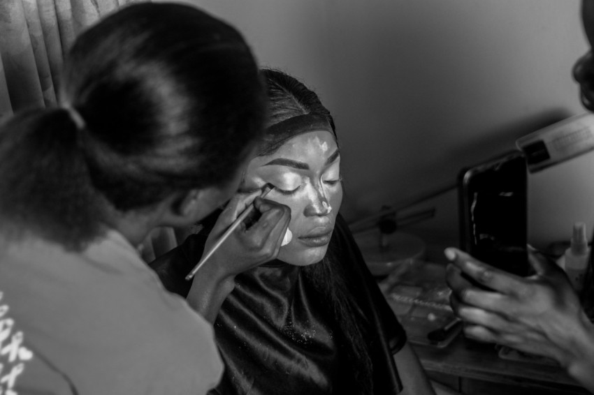 a black and white photo of a woman using a cell phone