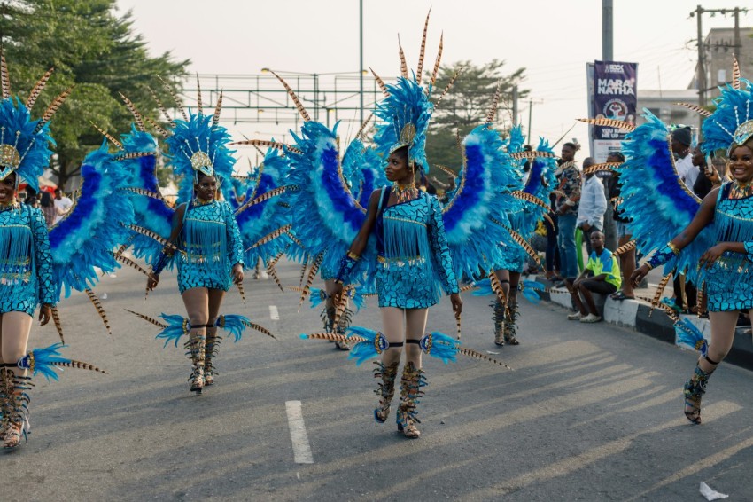 a group of women in blue costumes walking down a street