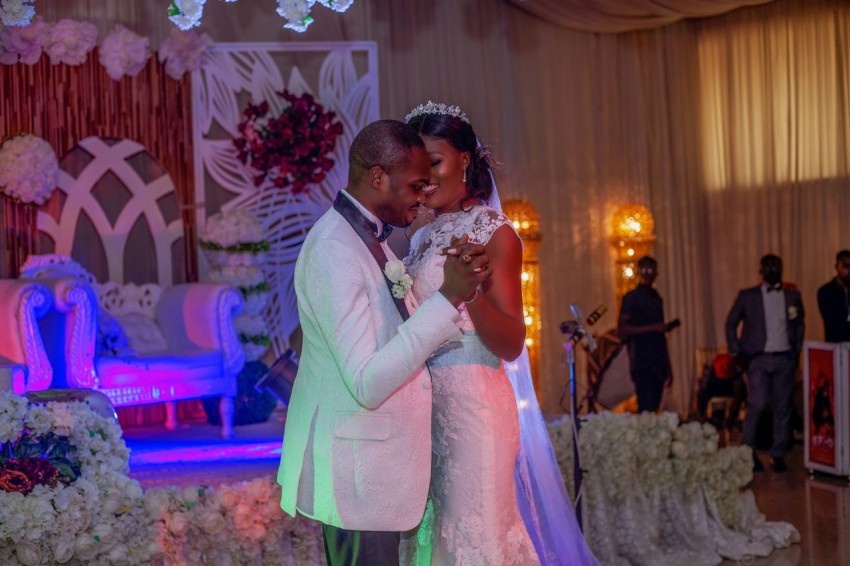 man in gray suit kissing woman in white wedding dress e8Ys