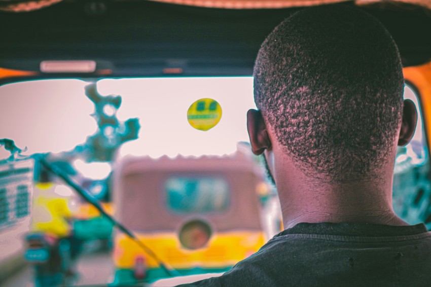 a man is driving a truck with a yellow ball in the back