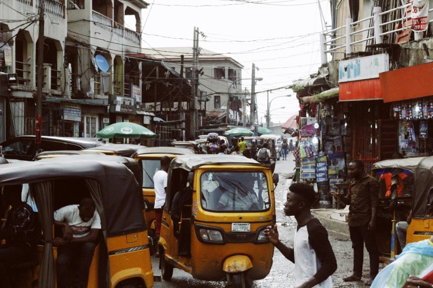 people on street and different vehicles near buildings during daytime