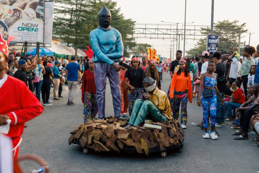 a group of people standing around a statue of a man sitting on top of a