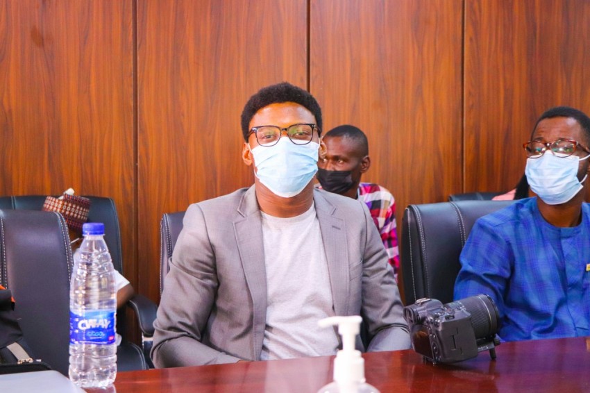 a group of people sitting around a table wearing masks