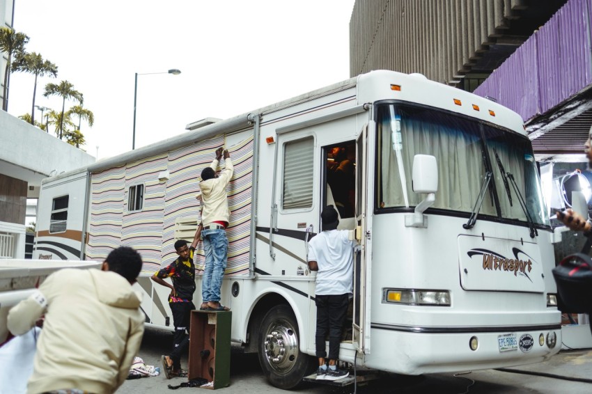 a group of people loading a white truck with a large load