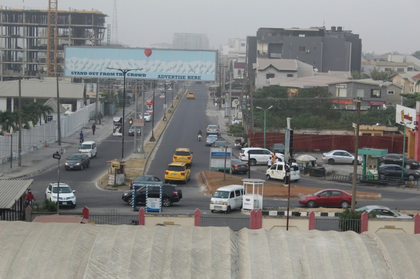 a city street filled with lots of traffic next to tall buildings