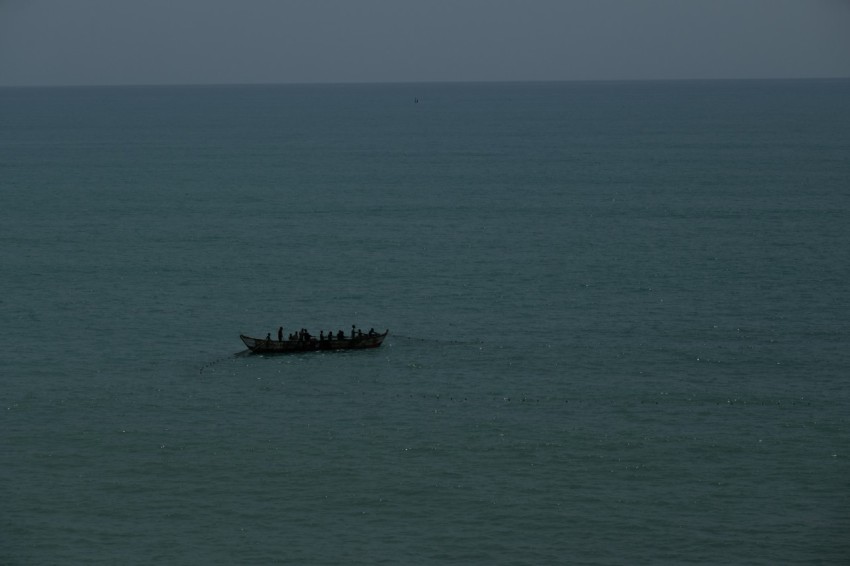 a group of people on a boat in the middle of the ocean