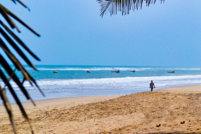 a person standing on a beach next to the ocean t Snu