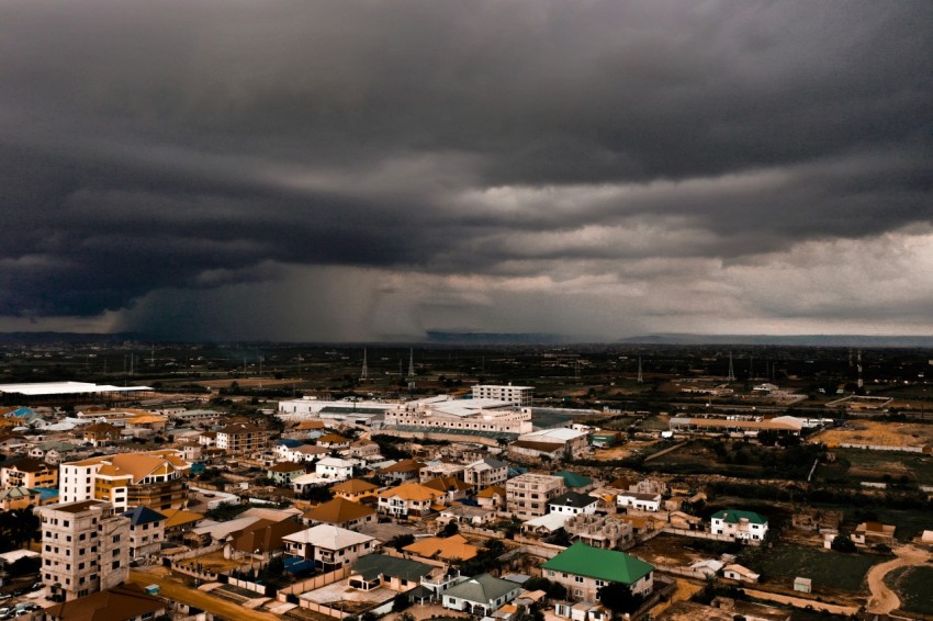 city with high rise buildings under gray clouds during daytime