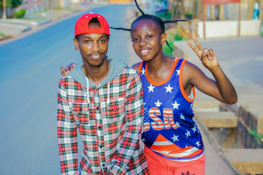 man in blue tank top beside boy in red and white checkered button up shirt