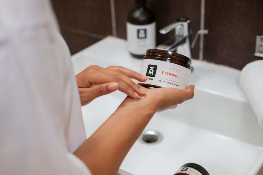 a person holding a jar of peanut butter in front of a sink