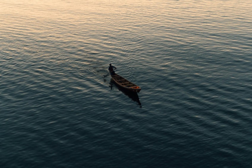 a person in a canoe paddling on the water SjNEKdNT8