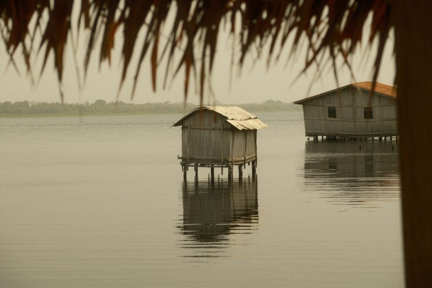 a couple of houses sitting on top of a body of water m2e