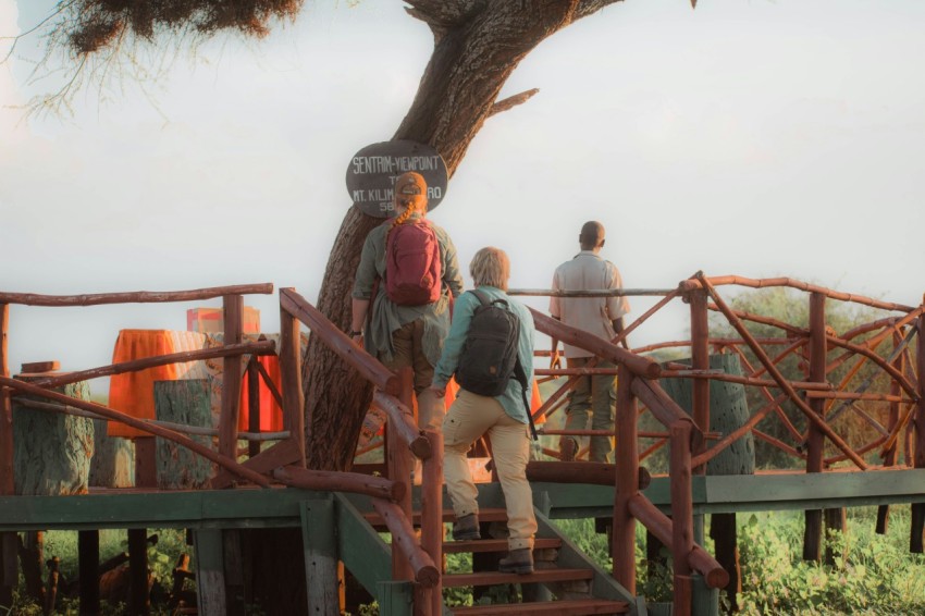 a group of people standing on top of a wooden bridge