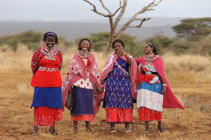 a group of women standing next to each other in a field JMz