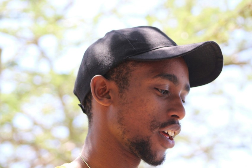 a man wearing a black hat while talking on a cell phone BqVR